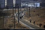 Nordkoreanere færdes til fods og på cykel langs en jernbanestrækning i udkanten af Pyongyang. Arkivfoto. 