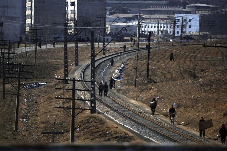 Nordkoreanere færdes til fods og på cykel langs en jernbanestrækning i udkanten af Pyongyang. Arkivfoto. 