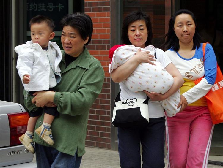 Kinesiske mødre med deres børn står foran et børnehospital i Beijing. Hospitalet er et af de hospitaler, der er blevet udvalgt til at behandle tilfældene af hånd-, fod- og mundsyge. 