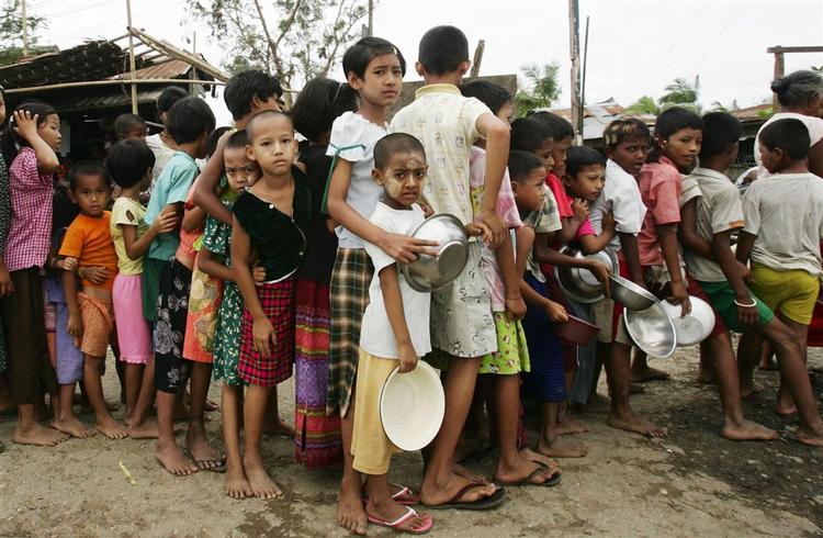 Børn står i kø for at få et gratis måltid mad i udkanten af hovedstaden Yangon. 