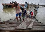 Lokale reparerer en mole ved et havneanlæg i Myanmars største by, Yangon. 
