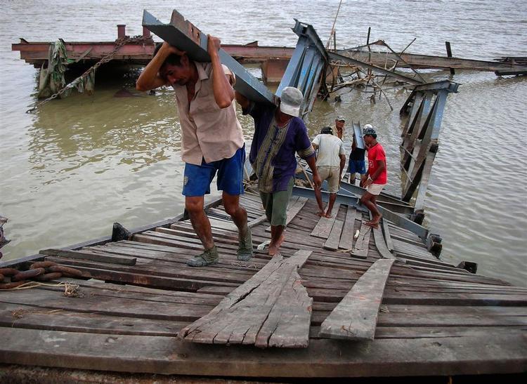 Lokale reparerer en mole ved et havneanlæg i Myanmars største by, Yangon. 