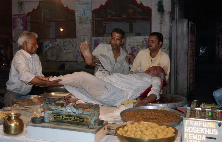 En såret person bæres væk fra en af de mange eksplosioner i den indiske by Jaipur tirsdag. Mellem 45 og 60 meldes dræbt. 
