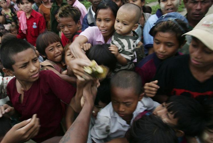 En lokal donor fra området omkring hovedstaden Yangon uddeler bananer til nogle af de overlevende efter cyklonen Nargis. 