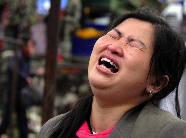 En overlevende kvinde efter jordskælvet i Sichuan-provinsen i Kina mandag. Næsten 15.000 er døde. 