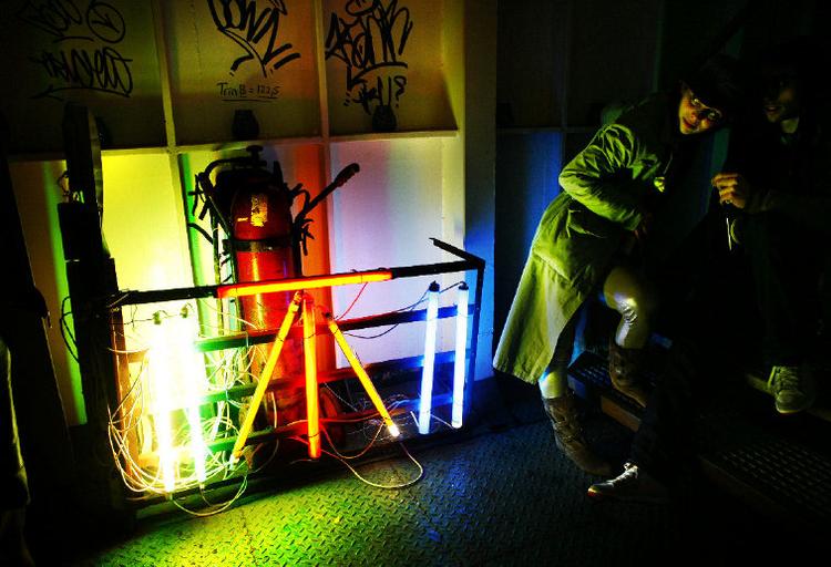 Redningsbælter og rustne kæder har fået selskab af neonkunst og lysstofrør. Fredag aften blinker båden endnu en fest i gang. 