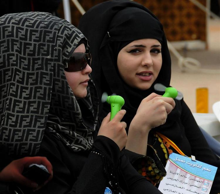 Kvinder forsøger at køle sig lidt ned foran et valglokale for kvindelige vælgere i Kuwait. Det lykkedes ikke, at få en kvinde i parlamentet. 