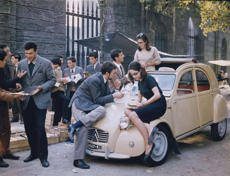 Universitetsungdommen flokkes om en Citroën 2 CV, sikkert en gang i 60'erne. Bilens nummerplade viser dog, at den ikke er fra Paris, men fra Milano. Foto: Citroën 