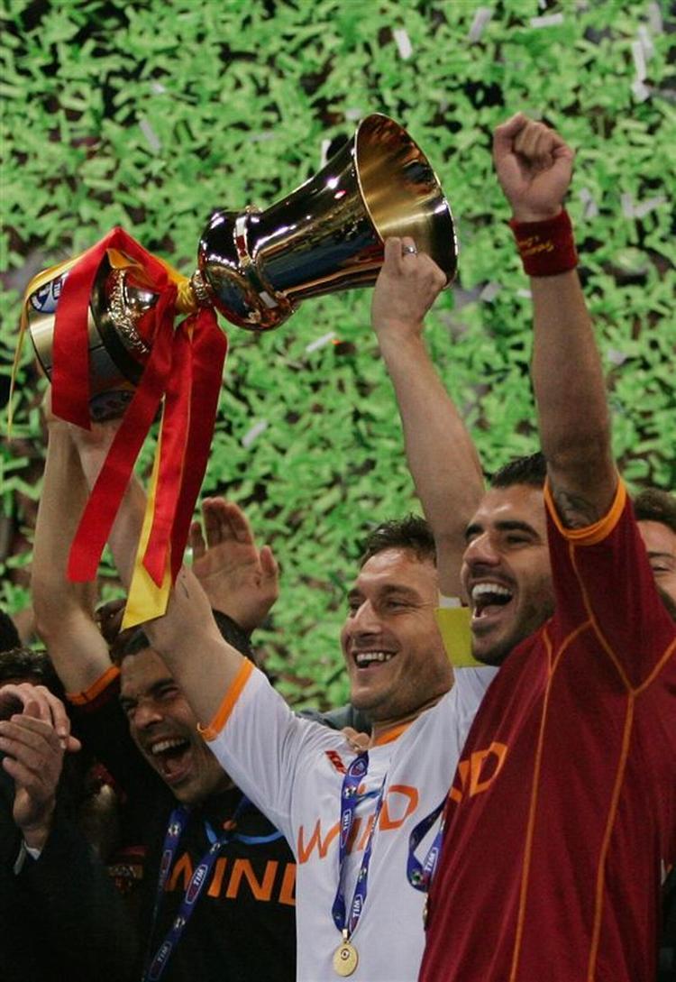 Romas anfører Francesco Totti i den hvide trøje og jubler sammen med blandt andre Simone Perrotta. 