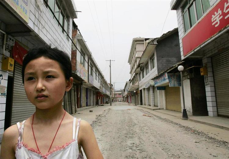 En pige venter på sin familie, så de kan blive evakueret fra landsbyen Jiangyou. Den ligger tæt ved søen Tangjiashan, der er ved at briste. 