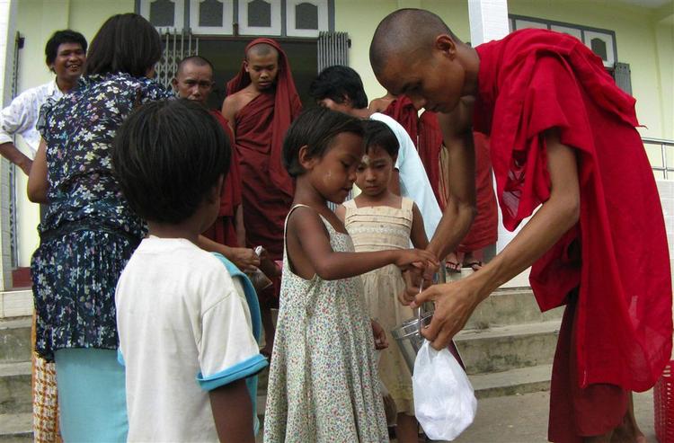 En buddhistisk munk modtager mad fra gavmilde borgere i Myanmar. Snart kan det være slut med amerikanernes forsøg på at hjælpe med nødhjælp. 
