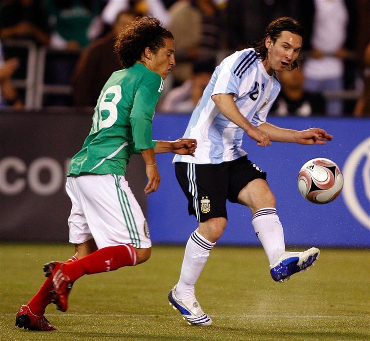 Lionel Messi (til højre) i nærkamp med Mexicos Andres Guardado. 