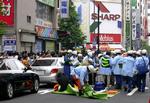 Ambulancefolk giver de sårede behandling på stedet i Tokyos centrum, hvor en mand har stukket dem ned. 