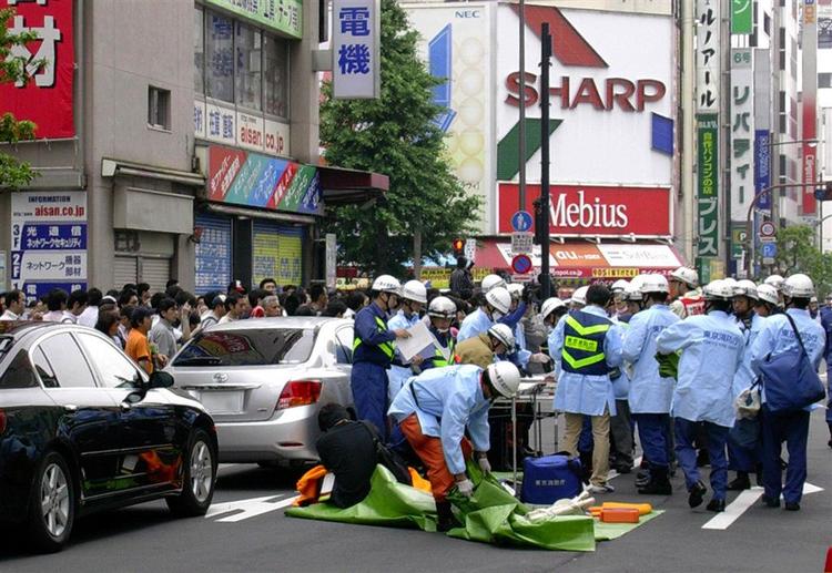 Ambulancefolk giver de sårede behandling på stedet i Tokyos centrum, hvor en mand har stukket dem ned. 