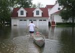 Storme og tornadoer har ødelagt bygninger og oversvømmet store områder i USA's midtvesten. Her har en mand valgt kanoen i Iowa. 