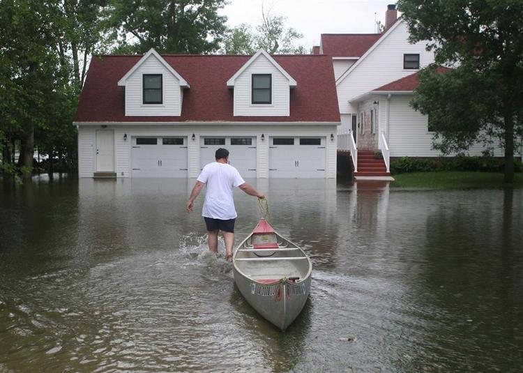 Storme og tornadoer har ødelagt bygninger og oversvømmet store områder i USA's midtvesten. Her har en mand valgt kanoen i Iowa. 