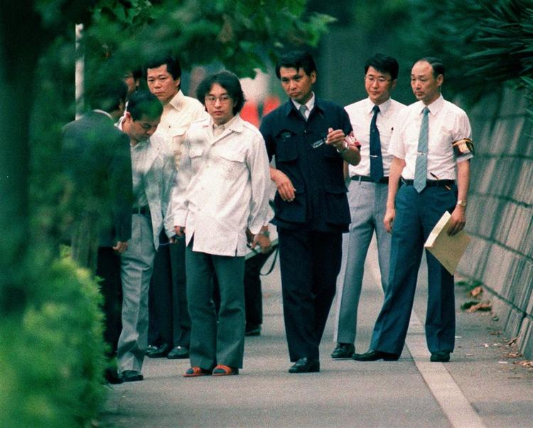På dette billede fra 1989 ses Tsutomu Miyazaki (med briller) sammen med japanske betjente på et af steder, hvor han begik sine forbrydelser. 