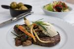 Nimbs gæster kan overvåge hver detalje i tilberedningen af maden i det store lokales tre køkkenregioner. Her en ribeye med pisket smør, sherryeddike og estragon, syltede sæsonsvampe og lidt nye gulerødder. 