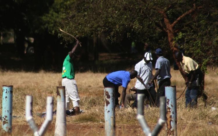 Medlemmer af en af Mugabes militser banker løs på folk, der ville til oppositionens møde i Harare i dag. 