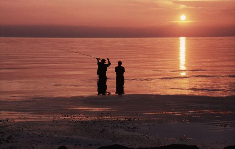 Her er det endnu for tidligt til, at det egentlige natfiskeri kan begynde. Men to fiskere benytter det sidste lys til at teste, om alt er i orden, og om kastet fungerer inden nattens komme, så alt er klart, når havørrederne nærmer sig land. 