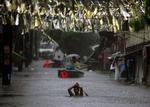 Gaderne stod under vand, da tyfonen Fengshen ramte Filippinernes hovedstad, Manila. Nu har stormen ramt Kina og dræbt ni personer. 