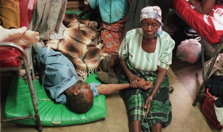 En kvinde holder en aids-syg slægtning i hånden på et hospital i Lilongwe, Malawi. Arkivfoto. 