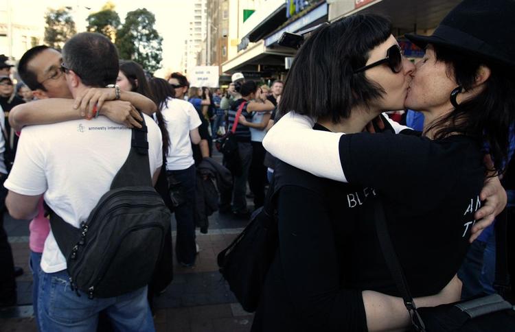 Homoseksuelle par kysser og krammer, mens pavens katolikker samles i Sydney. 