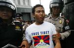 Cadel Evans kørte med en T-shirt som denne under den gule trikot på Tour de Frances 15. etape. Her bliver en tibetansk aktivist anholdt under en protest, da den olympiske flamme passerede gennem Indonesien. 