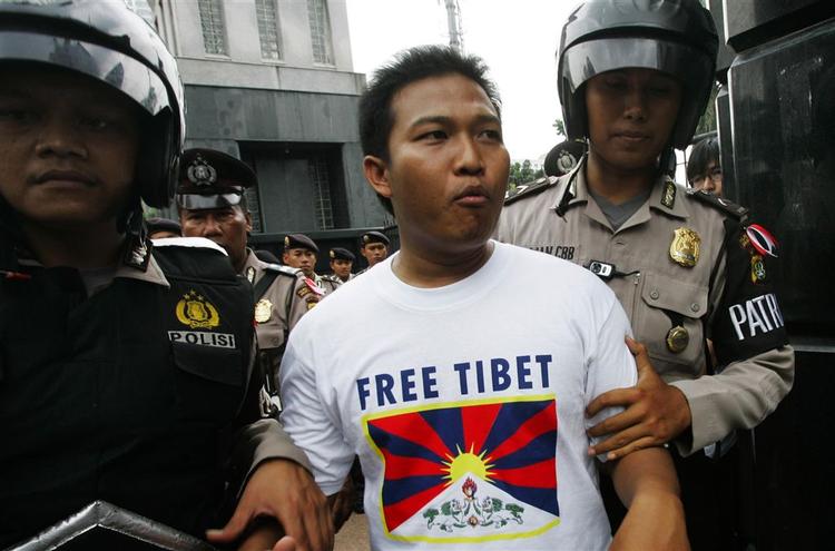 Cadel Evans kørte med en T-shirt som denne under den gule trikot på Tour de Frances 15. etape. Her bliver en tibetansk aktivist anholdt under en protest, da den olympiske flamme passerede gennem Indonesien. 