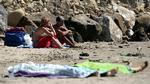 I en time fortsatte de italienske badegæster på stranden ved Napoli med at slikke sol og spise deres medbragte mad, inden politiet kom og bar de to lig væk. Foto: Althea/EMMEVI 