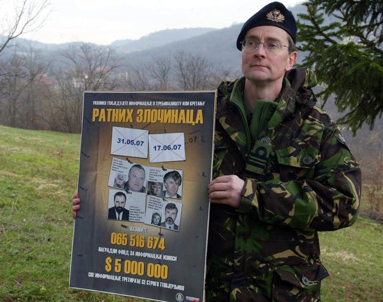 En talsmand for EU-styrken EUFOR fremviste i april i år en plakat over eftersøgte mistænkte krigsforbrydere for pressen. Billedet er taget ved en husundersøgelse syd for Sarajevo i jagten på Radovan Karadzic (billedet øvertst til højre). 