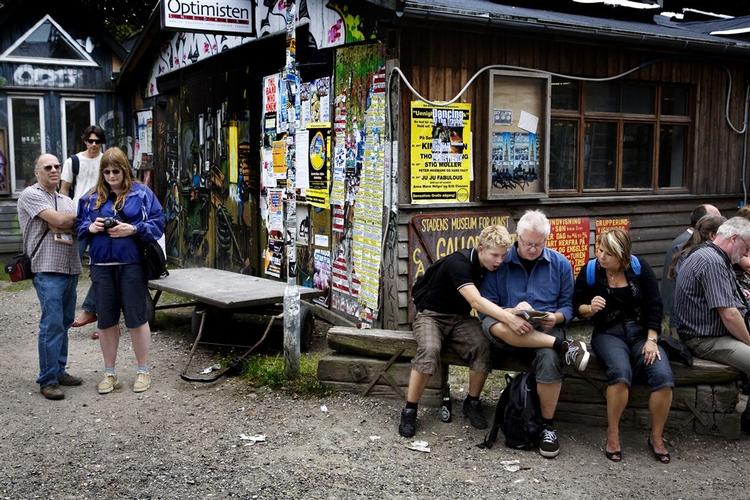 Turister sidder klar til at følge med på tur rundt på Christiania. 