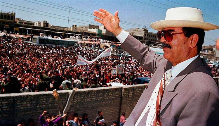 Den ægte Saddam Hussein vinker til sine undersåtter i Bagdad i april 1998. 