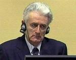 Sådan så Karadzic ud, da han sad i krigsforbryderdomstolen i Haag. Skægget, han havde, da han levede under en anden identitet, er væk, og håret er trimmet. 