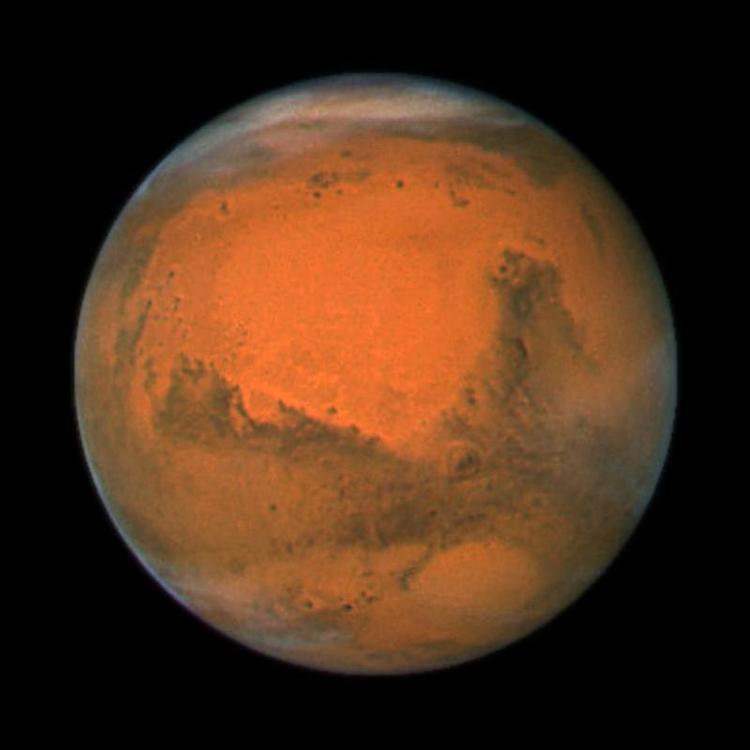 I dag er den rød, men kan måske blive pletvist hvid. I hvert fald falder sneen fra skyerne over planeten. Arkivfoto. 