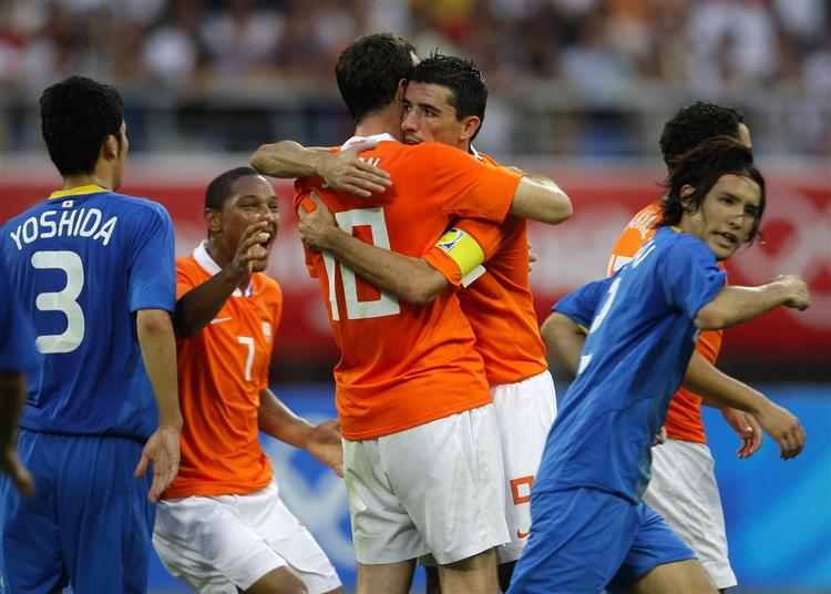 Den langlemmede Gerald Sibon lykønskes af anfører Roy Makaay med den vigtige scoring i Shenyang. 