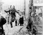 !5. august 1961. En østtysk grænsesoldat flygter over Berlinmuren, mens han kan. Siden blev hundredvis af civile skudt, da de forsøgte at flygte. 