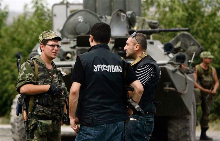 Russiske soldater i samtale med en georgisk politimand nær hovedstaden Tblisi. 