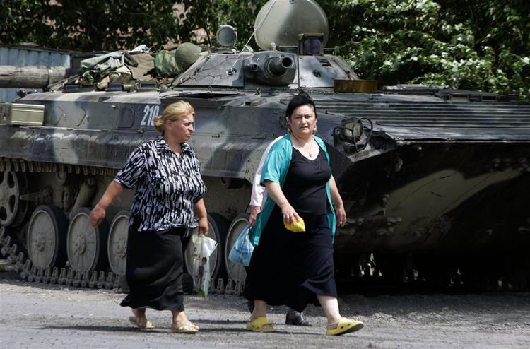 Georgiske kvinder går forbi en russisk kampvogn i dag i Gori, Georgien. 