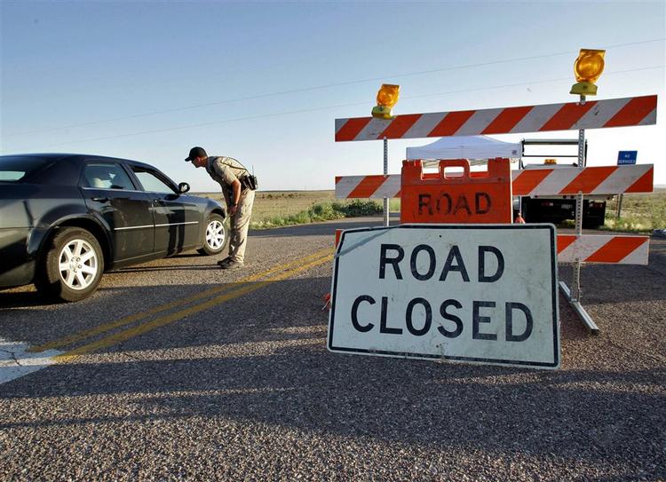 En politimand fra hualapai-stammen standser trafikken mod Supai i Arizona, hvor oversvømmelser har overrasket mennesker, der befandt sig i Grand Canyon. 