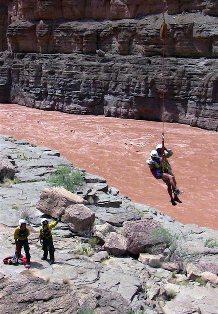 En turist hjælpes op fra Grand Canyon, som søndag blev oversvømmet efter et dæmningsbrud. 