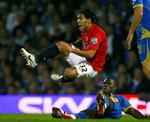 Unites Carlos Tevez flyver forbi Portsmouths Pape Bouba Diop. 