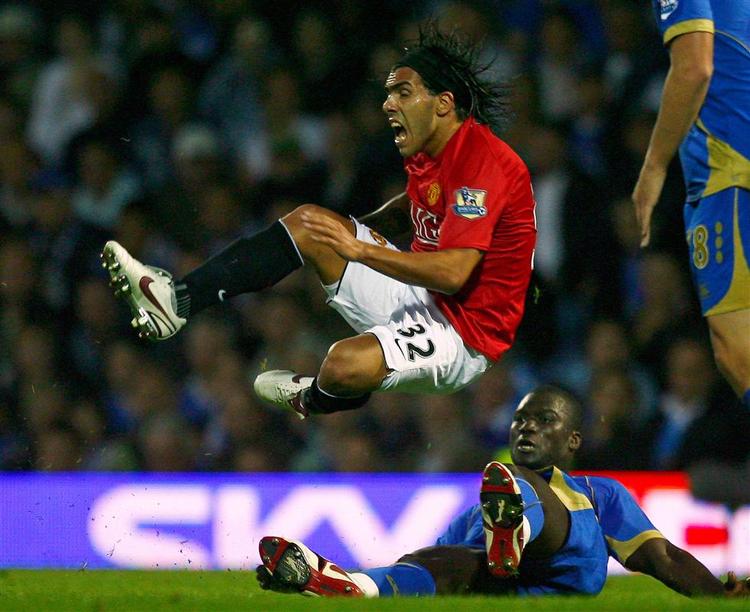 Unites Carlos Tevez flyver forbi Portsmouths Pape Bouba Diop. 