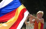 En ossetisk kvinde svinger med både det russiske ogm det syd-ossetiske flag efter meddelsen om den russiske anerkendelse. 