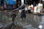 En kvinde forsøger at fjerne forhindringer i en oversvømmet gade i Port-au-Prince, Haiti. Orkanen Gustav er på vej henover Haiti og Cuba. 