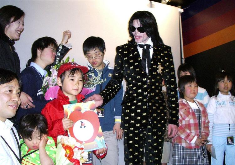 Michael Jackson og en flok forældreløse  børn ved fan-arrangement i Tokyo i marts sidste år. 