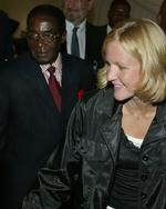 Kirsty Coventry er blevet nationalhelt i Zimbabwe oven på sin olympiske succes. Præsident Robert Mugabe, som hun her ses i selskab med, kalder hende 'golden girl'. 