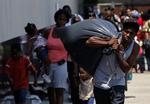 Flere hundrede tusinde flygter i øjeblikket fra deres hjem i Louisiana. Her bærer Jeffrey Vannor familiens vigtigste ejendele, inden familien lader sig evakuere fra Amtrak Station i New Orleans. 