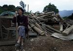En ældre kinesisk kvinde sidder ved siden af sit ødelagte hus efter det jordskælv, der lørdag ramte Kinas Sichuan-provins. 