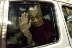 Dalai Lama vinker fra bilen, da han kører væk fra hospitalet i Mumbai. 